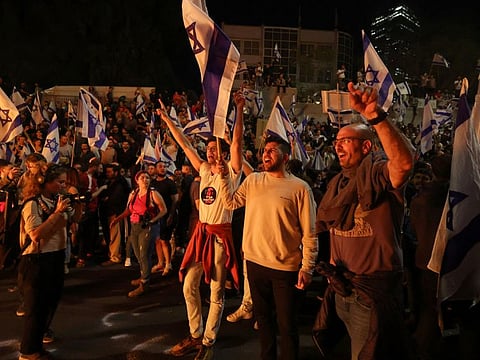 People attend a demonstration after Israeli Prime Minister Benjamin Netanyahu dismissed the defense minister and his nationalist coalition government presses on with its judicial overhaul, in Tel Aviv, Israel, March 26, 2023.