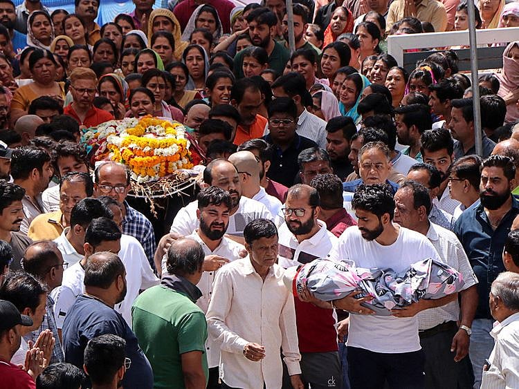 People carry the bodies of the victims after the roof of a stepwell in a temple complex collapsed in the central city of Indore, March 31, 2023.  