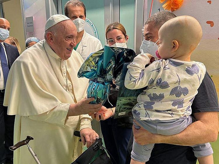 This photo taken and handout by The Vatican Media on March 31, 2023 shows Pope Francis visiting children at the oncology ward of the Gemelli hospital in Rome, the same hospital where the Pope was admitted to another ward on March 29 for bronchitis.  