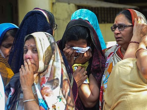 People carry the bodies of the victims after the roof of a stepwell in a temple complex collapsed in the central city of Indore, March 31, 2023.  