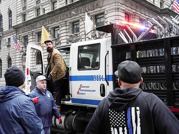 Plainclothes NYPD officers, some wearing prepare to deploy barricades near Trump Tower, in New York City on April 1, 2023.  