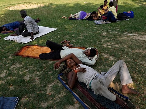 People rest in the shade of a tree on a hot afternoon in Lucknow in the central Indian state of Uttar Pradesh, on April 28, 2022.  