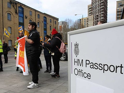 Members of the Public and Commercial Services (PCS) union stand on a picket line on the first day of a five-week strike by UK passport office workers, in London on April 3, 2023.  