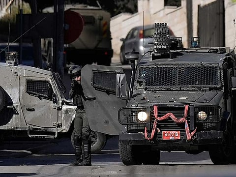 Israel policeman shoots tear gas during clashes with Palestinians during a raid in the West Bank city of Nablus, Monday, April 3, 2023. 