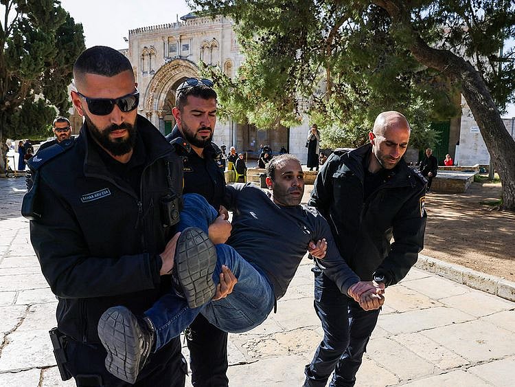 Israeli policemen detain a Palestinian at the Al Aqsa Mosque compound following clashes that erupted in Jerusalem on April 5, 2023.  
