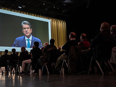UBS Chairman Colm Kelleher is seen on a giant screen during the general meeting of shareholders of UBS bank in Basel, on April 5, 2023, following the takeover by UBS of Credit Suisse hastily arranged by the Swiss government on March 19 to prevent a financial meltdown.