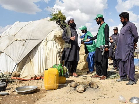 Census officials from the Pakistan Bureau of Statistics (C) speak to a Marri tribe man living in the remote mountainous area of Mawand as they collect info for a national census in southwest Pakistans Kohlu district, Balochistan province.  
