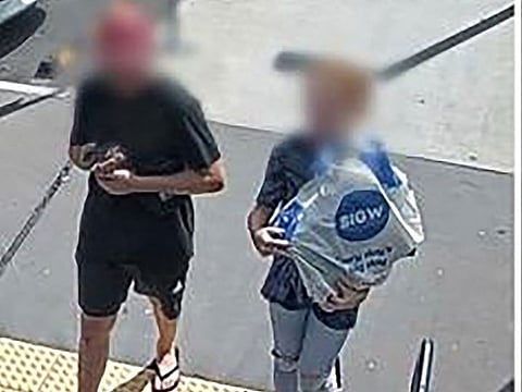  An undated handout framegrab received on April 6, 2023 from the Queensland Police Service shows a man (L) carrying a rare, wild platypus at a train station near Brisbane.