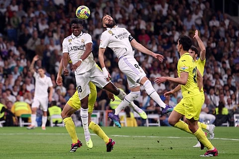 Real Madrid defender Aurelien Tchouameni (left) and forward Karim Benzema jump for a header during the Spanish league match against Villarreal CF at the Santiago Bernabeu stadium in Madrid.