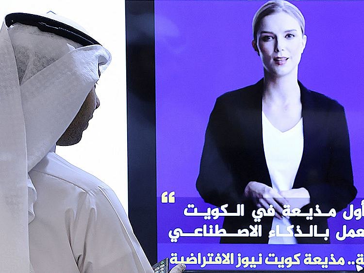 A journalist watches an introductory video by the 'artificial intelligence' anchor 'Fedha' on the twitter account of Kuwait News service, in Kuwait City.  