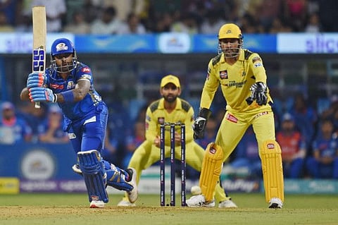 Mumbai Indians' Suryakumar Yadav (left) plays a shot as Chennai Super Kings' captain Mahendra Singh Dhoni (right) watches during the Indian Premier League match at the Wankhede Stadium in Mumbai.