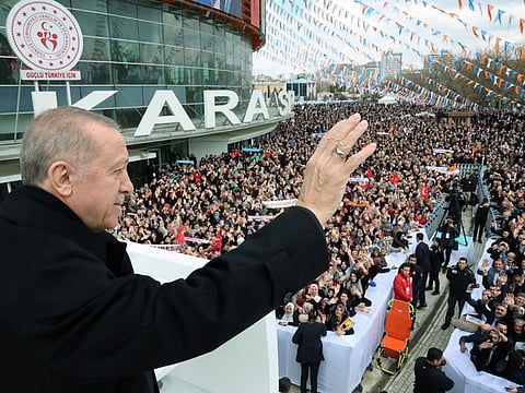 Turkish President Tayyip Erdogan greets the crowd before a meeting of his ruling AK Party to announce the party's election manifesto ahead of the May 14 elections, in Ankara on April 11, 2023.  