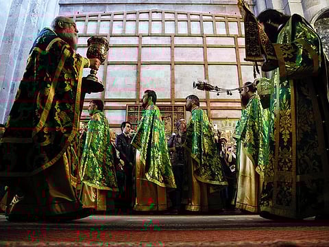 Greek Orthodox priests lead a procession during Orthodox Palm Sunday, marking the start of Holy Week that ends on Easter Sunday in the Church of the Holy Sepulchre in Jerusalem's Old City, on April 9, 2023.  