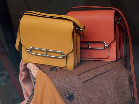 Leather Roulis handbags in the window of the Hermes International luxury clothing boutique on Rue du Faubourg Saint-Honore in central Paris.