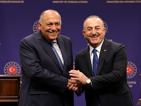 Turkish Foreign Minister Mevlut Cavusoglu and Egyptian Foreign Minister Sameh Shoukry shake hands during a news conference in Ankara on April 13, 2023.  