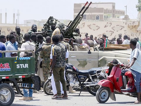 Sudanese greet army soldiers, loyal to army chief Abdel Fattah al-Burhan, in the Red Sea city of Port Sudan on April 16, 2023.