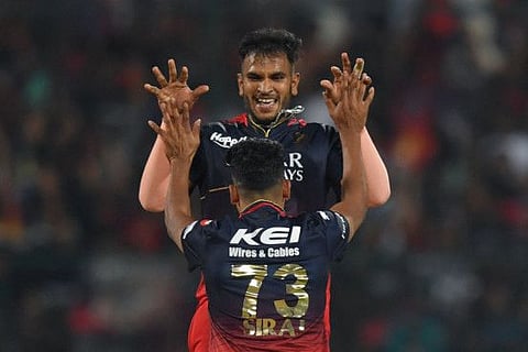 Royal Challengers Bangalore's Vijaykumar Vyshak (top) celebrates with his teammate Mohammed Siraj after taking the wicket of Delhi Capitals' Lalit Yadav during the Indian Premier League match at the M Chinnaswamy Stadium in Bengaluru.