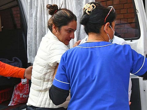 A member of medical staff helps India's record-holding climber Baljeet Kaur after being rescued from the treacherous Annapurna mountain range, at a hospital in Kathmandu on April 18, 2023.