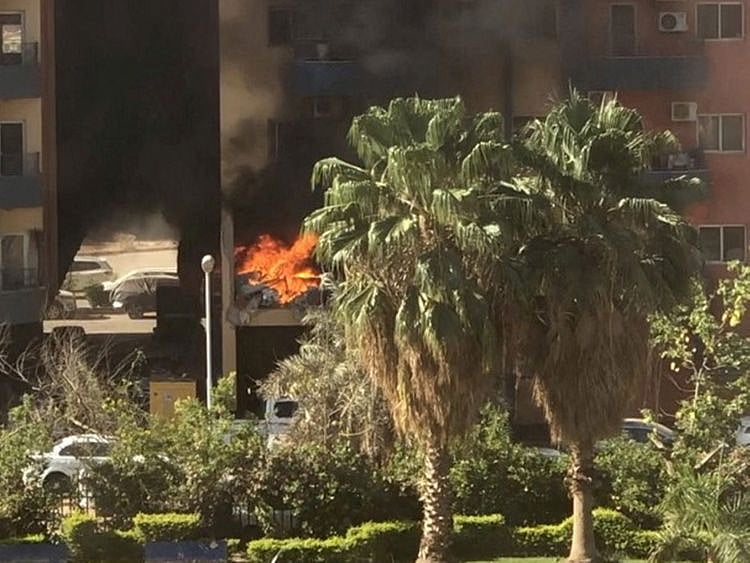 Smoke and fire rise from an apartment building in a residential complex, after a shell hit the building according to eyewitness, in Khartoum, Sudan April 19, 2023, in this still image obtained from a social media video.  