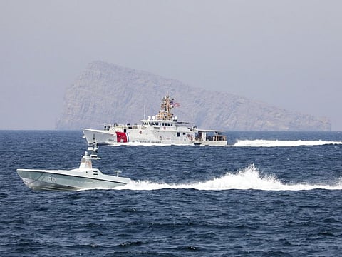 A US Navy L3 Harris Arabian Fox MAST-13 drone boat and the Coast Guard cutter USCGC John Scheuerman transit the Strait of Hormuz on Wednesday, April 19, 2023.  