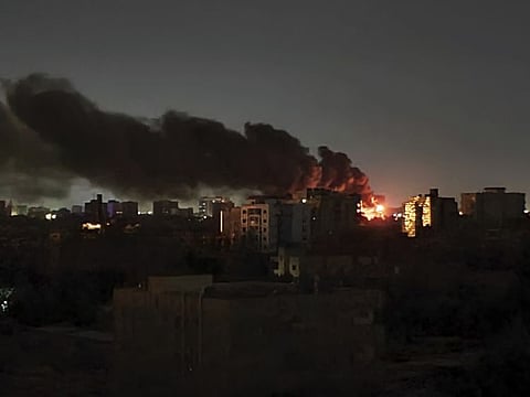 Smoke rises over the horizon as a fire burns after a strike in Khartoum.  