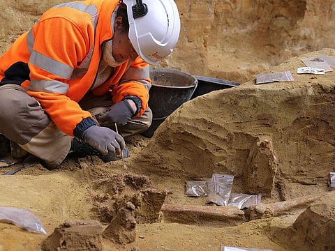 An archaeologist from the Institut National de Recherches Archeologiques Preventives (Inrap - National Institute for Preventive Archaeological Research) works on an ancient necropolis at Port-Royal metro station in Paris, on April 18, 2023.