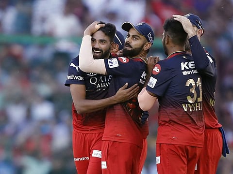 Royal Challengers Bangalore's Mohammed Siraj celebrates a dismissal of Punjab Kings with Virat Kohli and teammates in Mohali on Thursday.