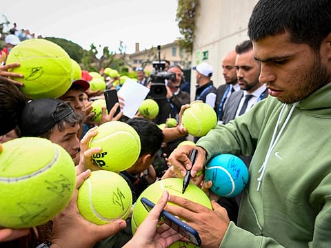 Spain's Carlos Alcaraz (right) signs autographs to fans after his win over Roberto Bautista Agut in Barcelona Open on Thursday.