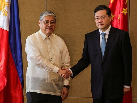 Chinese State Councilor and Foreign Minister Qin Gang and Philippine Foreign Affairs Secretary Enrique Manalo shake hands during the welcome ceremony prior to their bilateral meeting, in Manila, on April 22, 2023.  