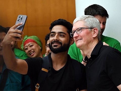 Tim Cook, chief executive officer of Apple Inc., poses for a selfie with a customer during the opening of the new Apple Saket store in New Delhi, India, on April 20, 2023. 