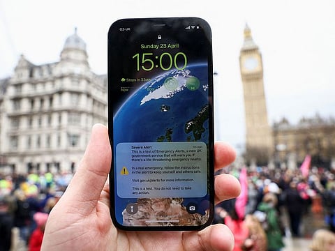 A person holds a phone showing the test message of Britain Emergency Alert, London, Britain April 23, 2023.  