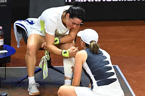Tunisia's Ons Jabeur speaks to Poland's Iga Swiatek after withdrawing from her semifinal in Stuttgart Open on Saturday.