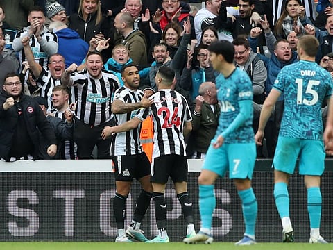Newcastle United's Callum Wilson celebrates scoring their sixth goal with Miguel Almiron while Tottenham players wear dejected look.