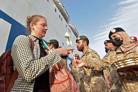 Members of the Saudi Navy Forces welcome evacuees arriving at King Faisal navy base in Jeddah on April 26, 2023 following a rescue operation from Sudan amid a US-brokered ceasefire between the country's warring generals.  