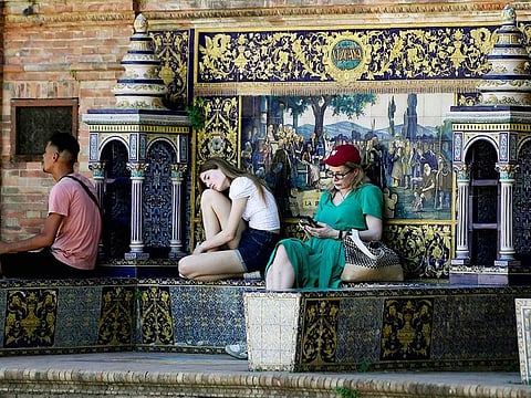 People rest in the shade in Seville on April 26, 2023 as Spain is bracing for an early heat wave. 