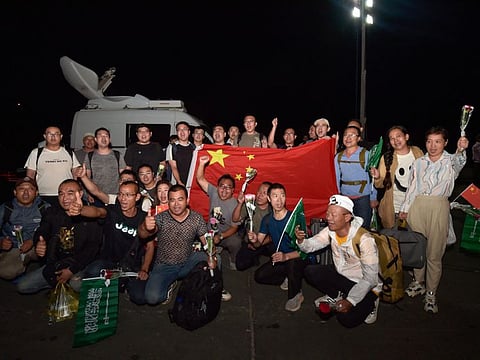 Chinese citizens evacuated from Sudan deploy a large national flag and upon their arrival at King Faisal navy base in Jeddah on April 26, 2023.  