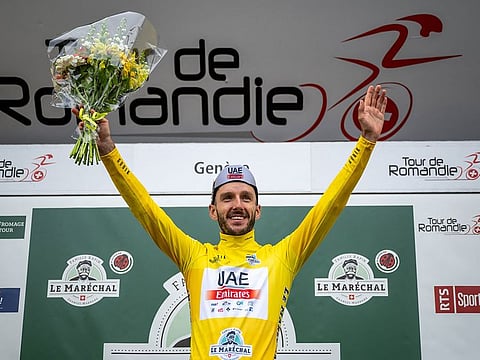 Adam Yates celebrates on the podium.