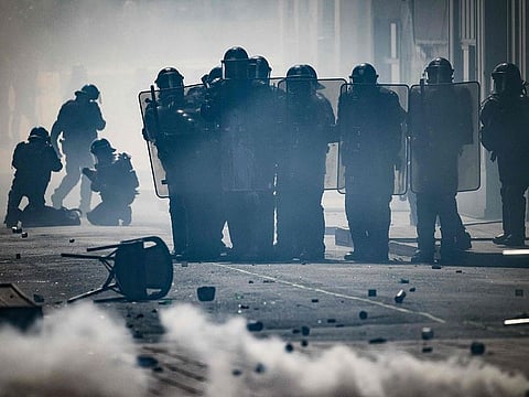 Riot Police stand in clouds of tear gas amid clashes with protestors.