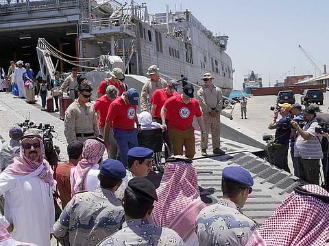 US Embassy staff and US Navy officials carry a person in a wheelchair from the US Navy fast transport ship, the USNS Brunswick which arrived with evacuees from Sudan at the Jeddah Sea Port, Jeddah, Saudi Arabia, May 1, 2023. 