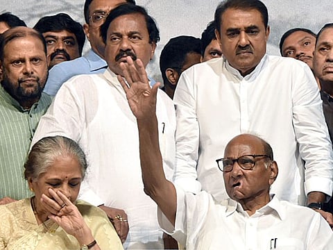 NCP President Sharad Pawar indicates to supporters to be quiet as wife Pratibha Pawar gets emotional while announcing his retirement from the party post at YB Chawan Auditorium in Mumbai on Tuesday. Party leader Praful Patel also seen. Pawar’s daughter Sule, nephew Ajit Pawar and grand nephew Rohit Rajendra Pawar are possible replacements. 