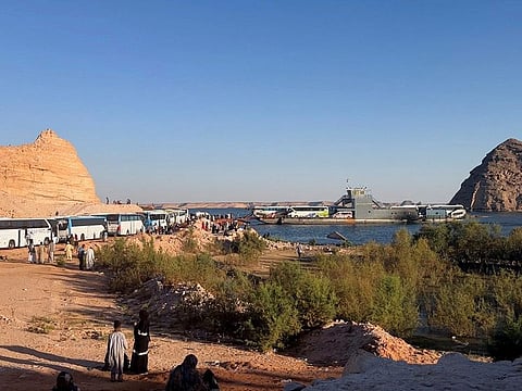 Sudanese and people from other nationalities wait to cross the river Nile in a ferry, after the crisis in Sudan's capital Khartoum, while on their way to Egypt through the Qustul border, in the Sudanese city of Wadi Halfa, on May 2, 2023.  