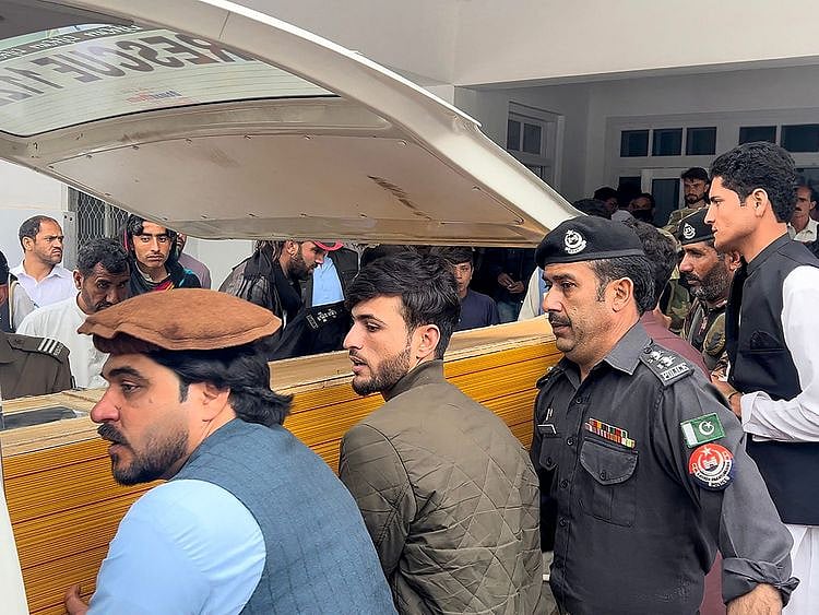 People carry a teacher's dead body into an ambulance from a hospital after violence inside a school in Parachinar, in Kurram district on May 4, 2023. - Five teachers and two labourers were gunned down on May 4 at a school in northwest Pakistan, in an attack linked to Sunni-Shiite sectarian tensions, police and government officials said.