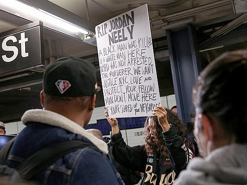 A woman holds a sign during a protest at the Broadway-Lafayette subway station, after a 30-year-old Jordan Neely acting erratically on a F subway train died on Monday afternoon after a fellow rider restrained him with a chokehold according to the police and a video of the encounter, in New York City, on, May 3, 2023. 
