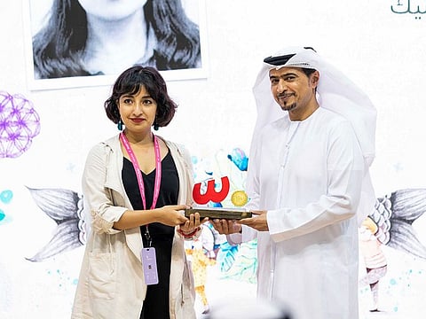 First-place winner Mariana Alcantara Pedraza (left) with  Ahmed bin Rakkad Al Ameri, Chairman of Sharjah Book Authority, at the awards ceremony