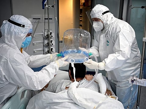 In this file photograph taken on December 30, 2021, medics help a patient to wear a new non-invasive technology that can reduce the need of intubation at COVID-19 intensive care unit (ICU) at The Institute of Clinical Cardiology (ICC) in Rome.  