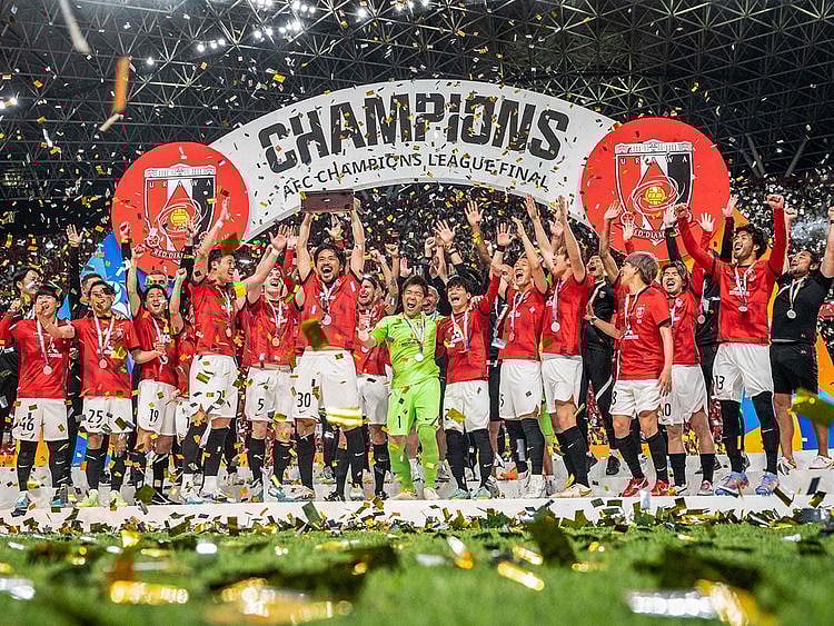 Urawa Red Diamonds players celebrate with the trophy