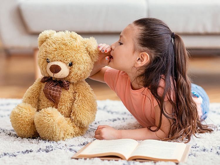 Girl talking to her teddy bear