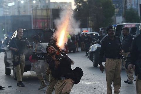 Police fire tear gas shells towards Pakistan Tehreek-e-Insaf (PTI) party activists and supporters of former Pakistan's Prime Minister Imran during a protest against the arrest of their leader, in Karachi on May 9, 2023.  