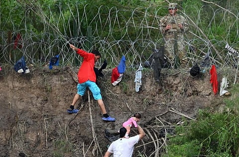 People try to get into the US through the Rio Grande, which is reinforced with a barbed-wire fence, as seen from Matamoros, state of Tamaulipas, Mexico on May 10, 2023.  