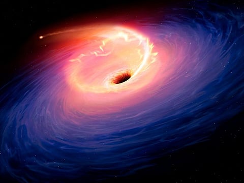 This handout image from Sheffield University shows an artists rendering of the tidal disruption event in F01004-2237, which is 1.7 billion light years from Earth. Astronomers said on May 11, 2023, that they have identified the "largest" cosmic explosion ever observed, called AT2021lwx, a fireball 100 times the size of our Solar System that suddenly began blazing in the distant universe more than three years ago.  